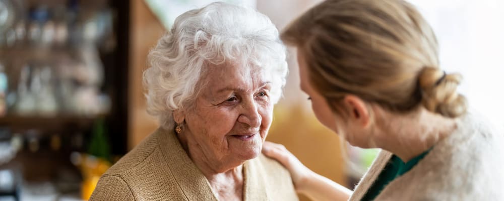 A staff member talking to a resident at Waverly Place in Albany, Oregon