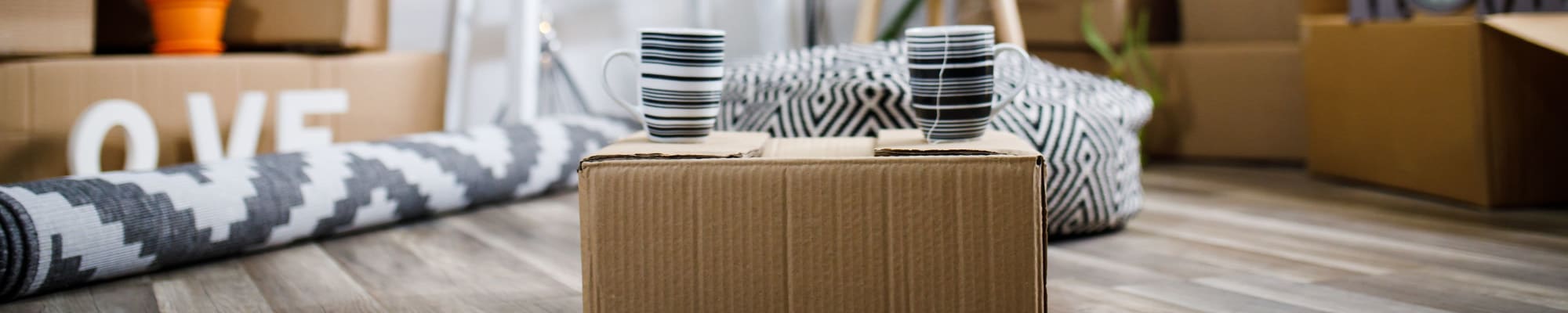 Two mugs of tea sitting on a moving box at U-Stor Walton Walker in Dallas, Texas