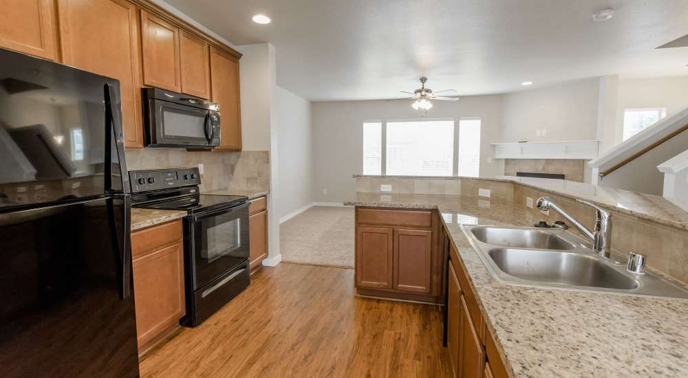 Kitchen with black appliances at Wynstone Townhomes in Puyallup, Washington