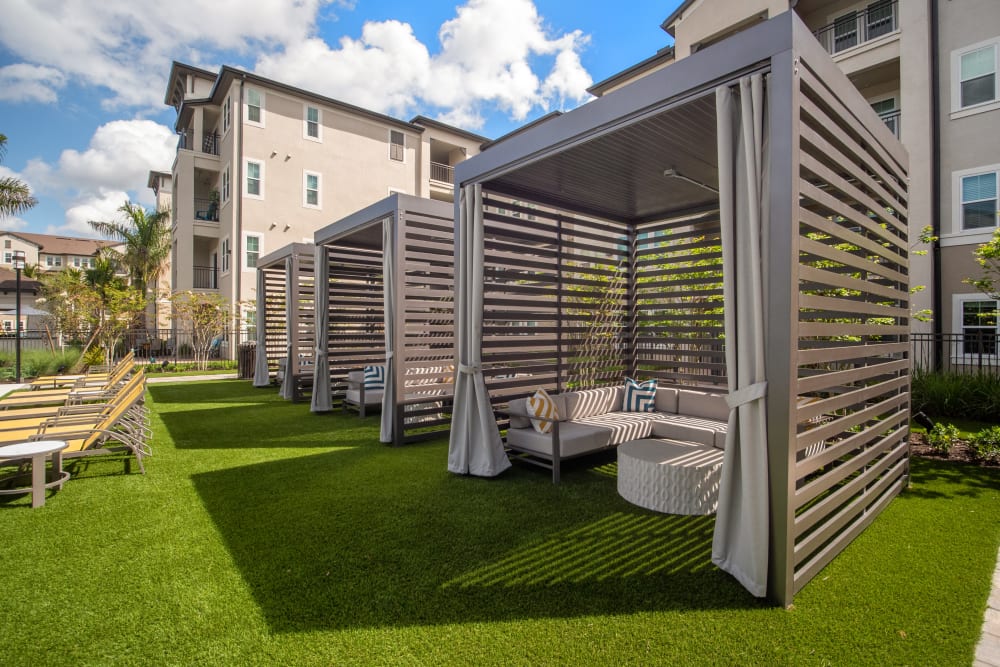 Private cabanas and lush green lawn at Murano at Three Oaks in Fort Myers, Florida