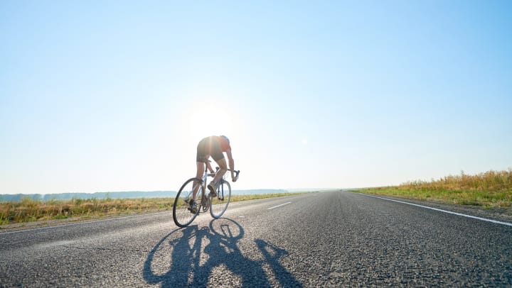 Person cycling on an open road.