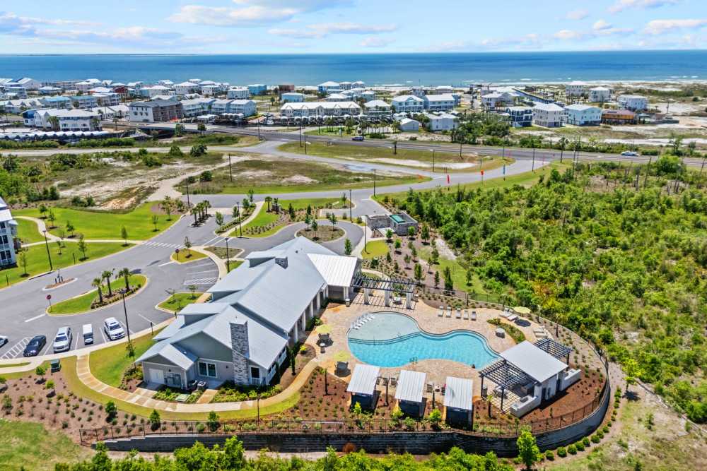 Aerial view of apartment buildings, pool, and Mexico Beach shoreline.