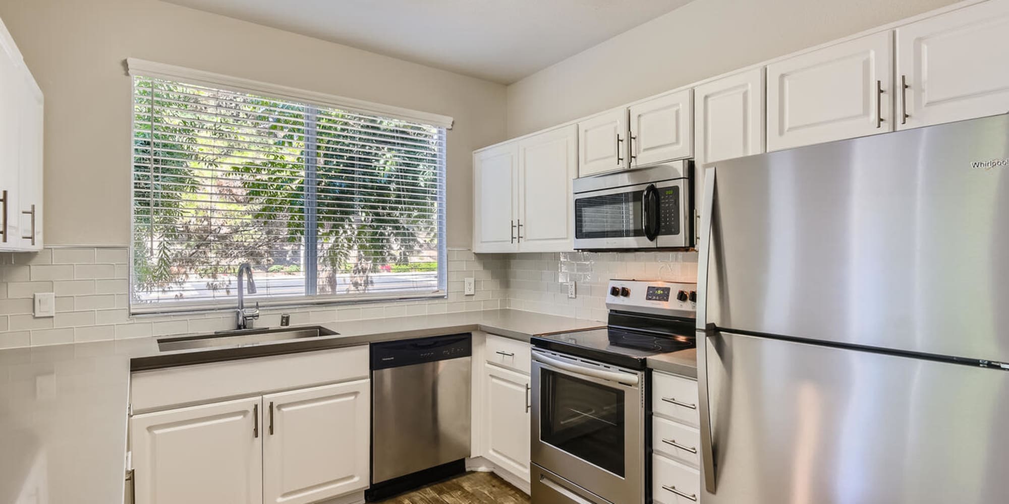 Kitchen with white cabinets, quartz counters, and stainless steel appliances