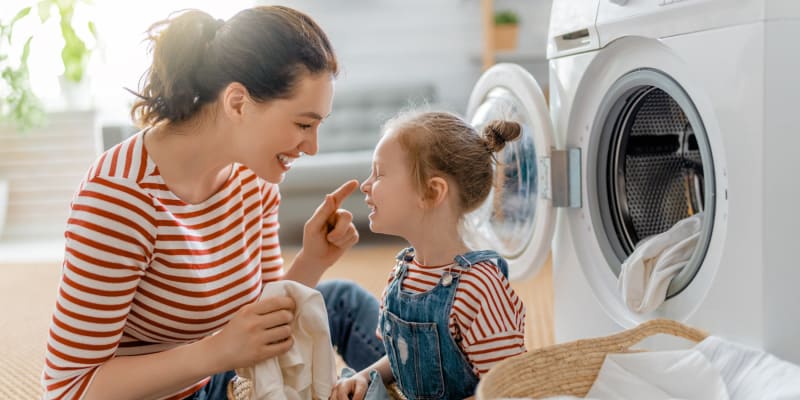 A resident folding laundry with her child at San Onofre I in San Clemente, California