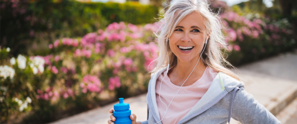 Woman walking with a water bottle and earbuds at Lake Forest at Swift Creek in Midlothian, Virginia