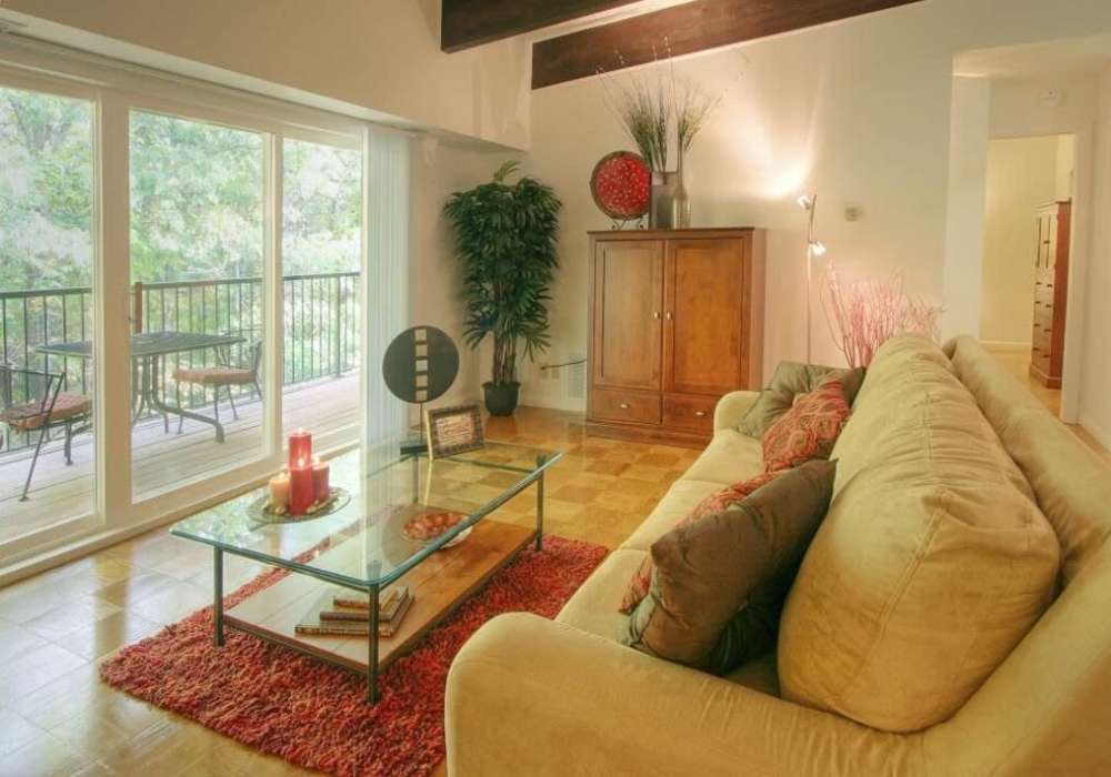 Cozy living room with access to balcony at Windsor Gardens Apartments in Rochester, New York