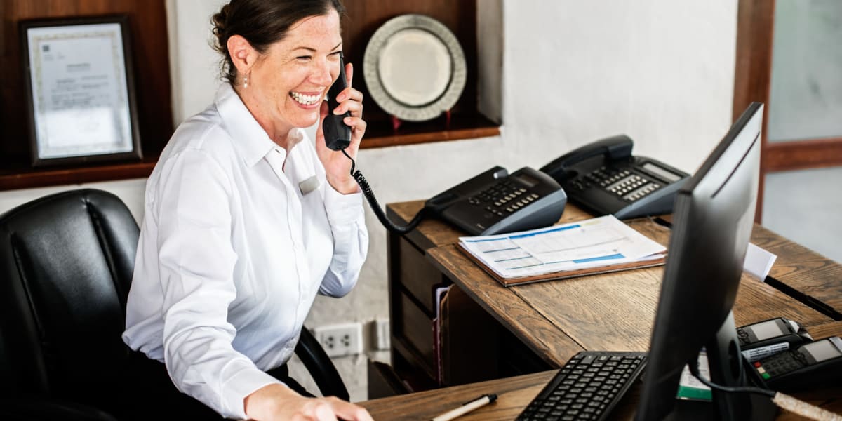 A smiling employee on a phone call at Key Storage in San Antonio, Texas