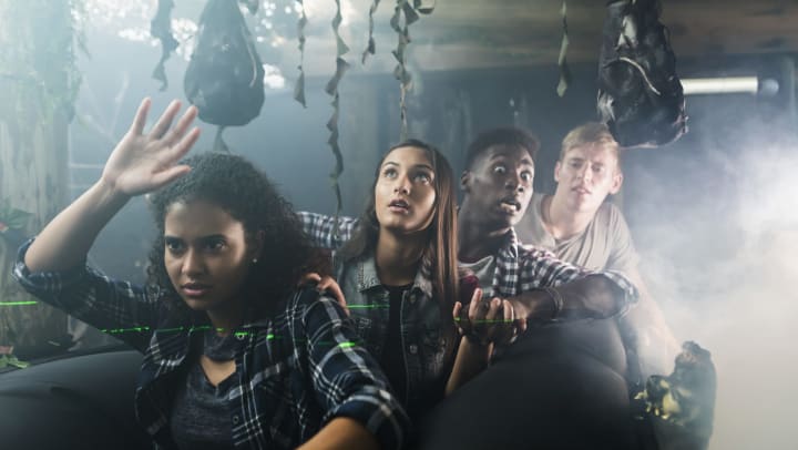 Group of friends walking through a haunted house holding hands near Olympus Corsair