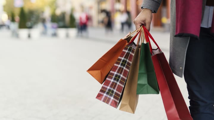 A person holding five shopping bags