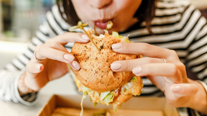 Woman eating a messy hamburger.