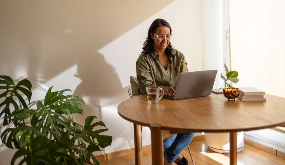 Resident with laptop in the living area at Amelia Apartments in Fayetteville, North Carolina