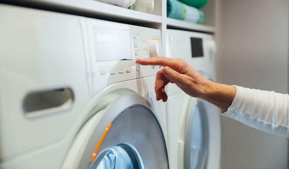 Resident using a In-home washer at Antioch Family & Senior Apartments in Antioch, California
