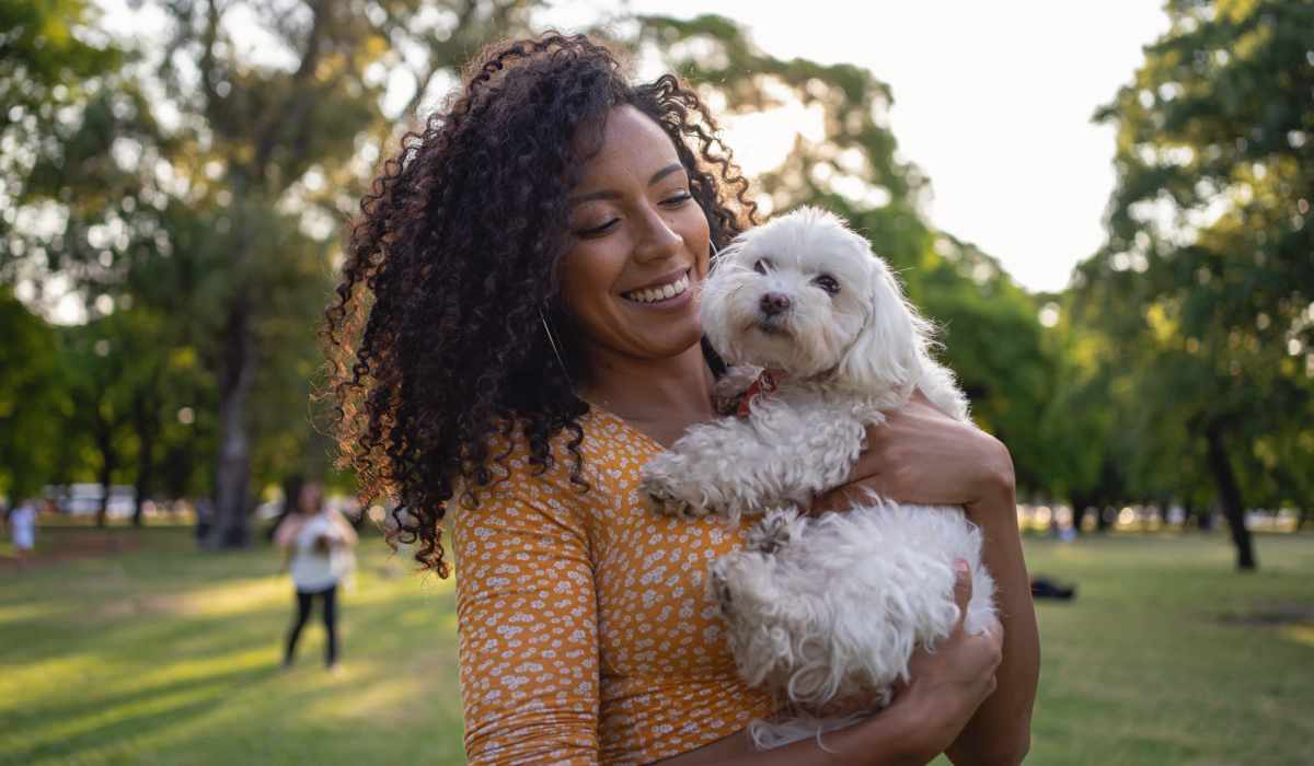 A woman cuddling het pet at The Crossroads At Downtown Boca in Boca Raton, Florida