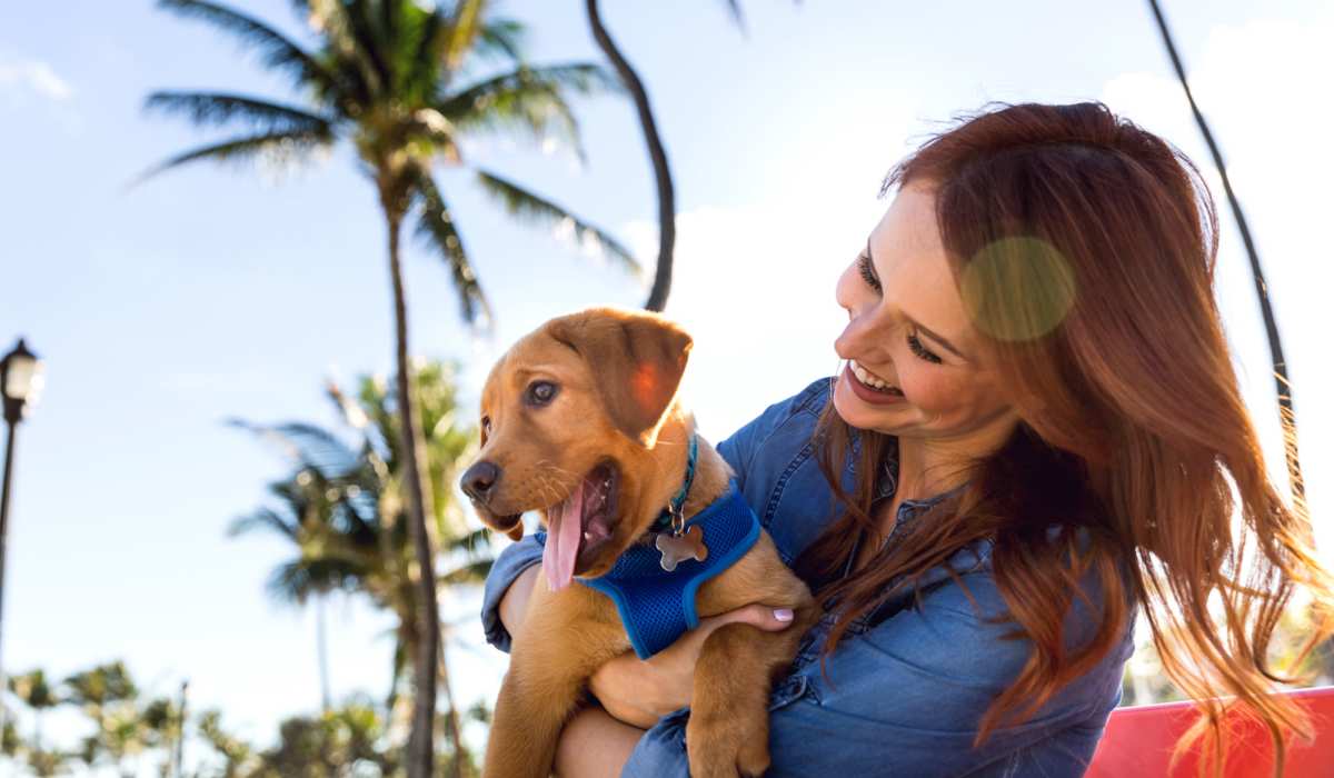 Resident woman with her dog at park near 1900 Ocean Apartment Homes in Long Beach, California