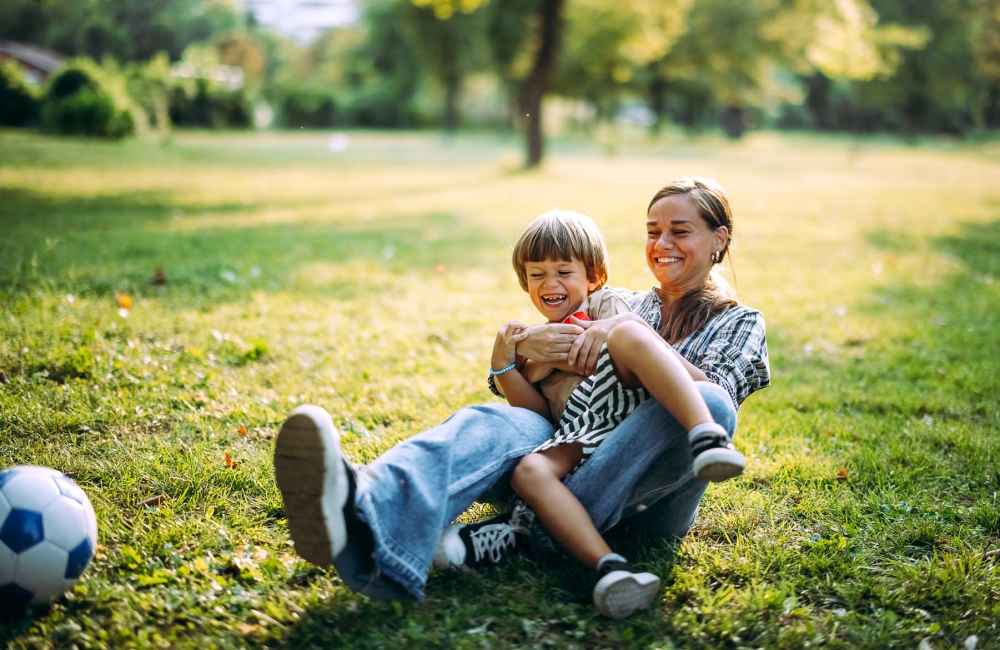 Resident woman playing soccer with her child near Bayside Villas Apartment Homes in South Pasadena, Florida