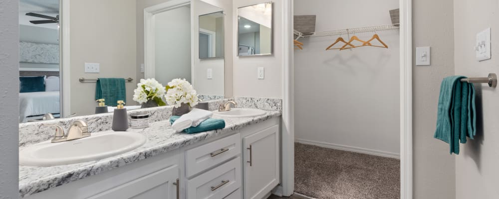 A double sink in an apartment bathroom with an attached closet at Regency Gates in Mobile, Alabama 