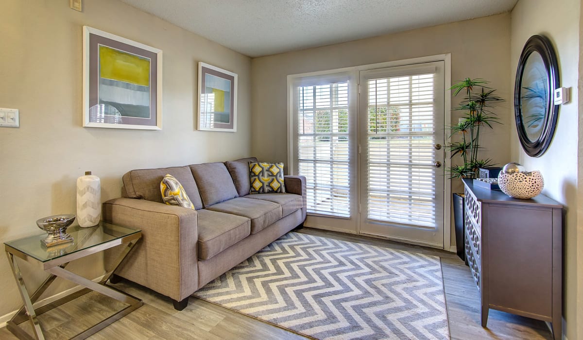 Furnished apartment living room with doors out to a private balcony at Canyon Grove in Grand Prairie, Texas