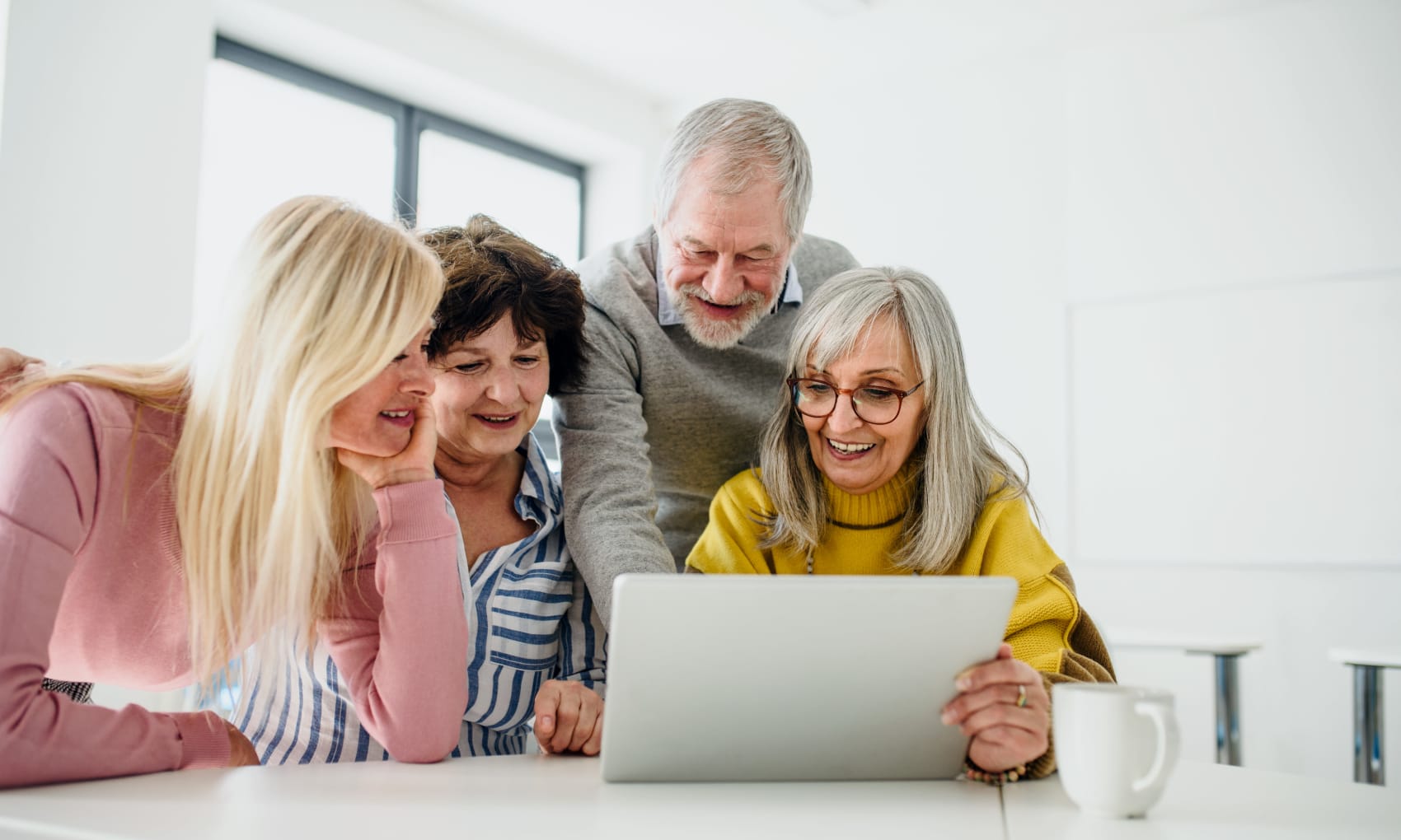 Residents looking at information on a laptop together at Estoria Cooperative Lakeville in Lakeville, Minnesota