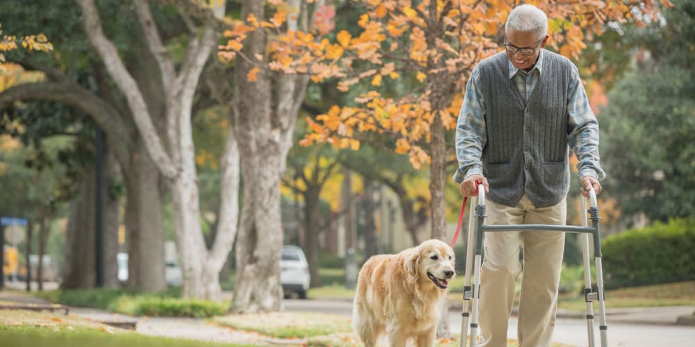 Resident walking dog at Vista Prairie at Monarch Meadows in North Mankato, Minnesota