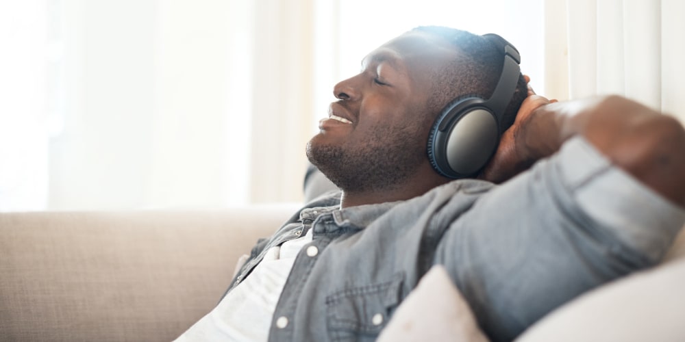 A resident relaxing and listening to headphones at Mission University Pines in Durham, North Carolina