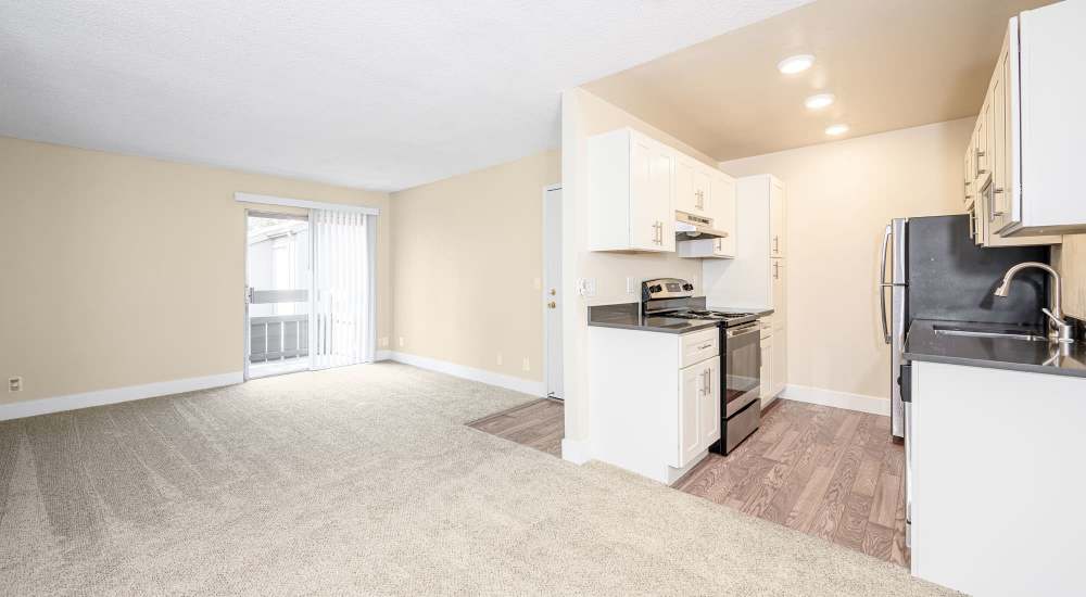 Modern kitchen and unfurnished living with carpet flooring at Vista in San Jose, California