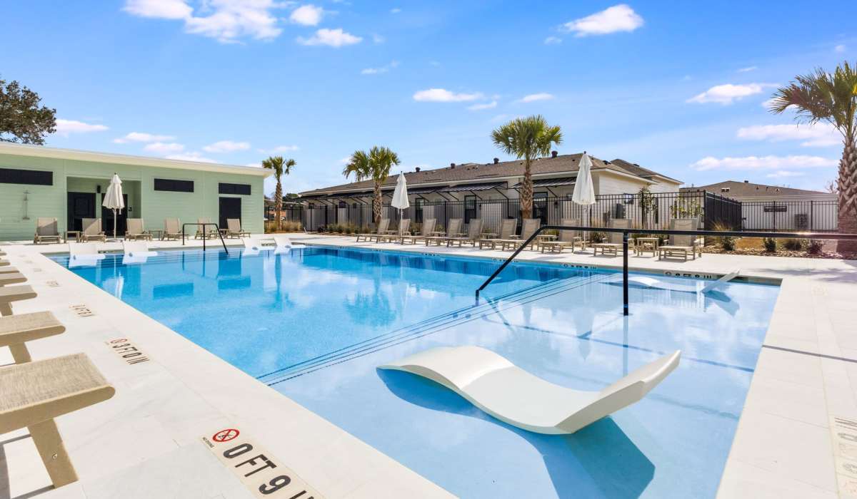 Community swimming pool with lounge seating at Trinity Villas in Lafayette, Louisiana