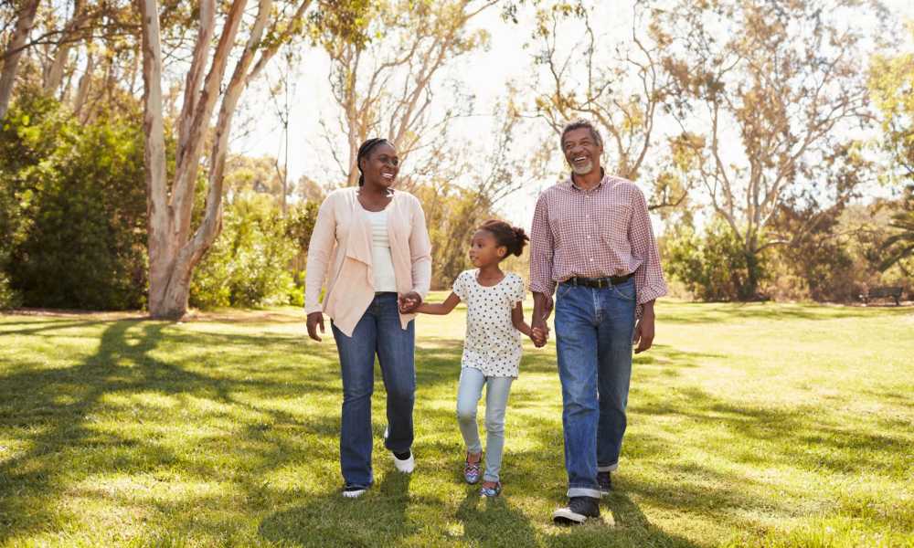 Family walking hand-in-hand in a green park, enjoying quality time together near Monarch Station in Louisville, Kentucky