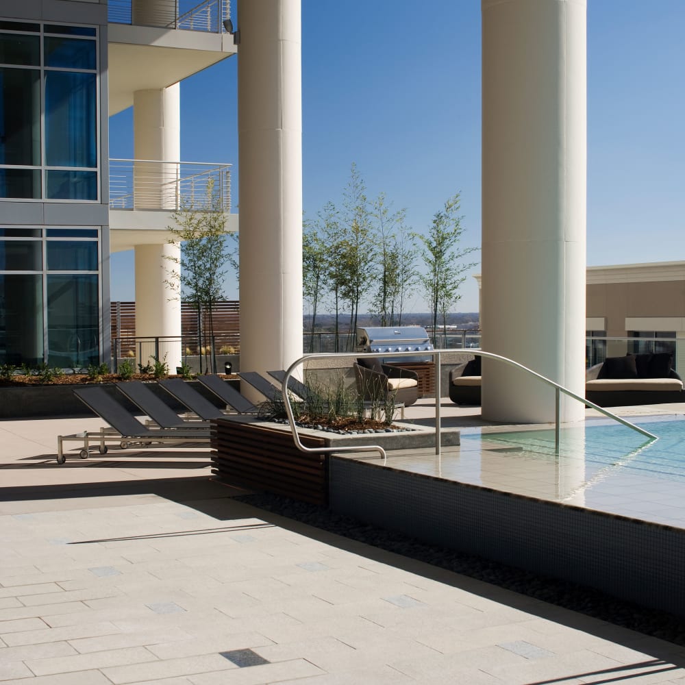 Poolside lounge chairs with BBQ grill at The Heights at Park Lane in Dallas, Texas