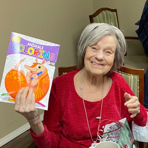 A resident holding up a pair of gloves at Canoe Brook Assisted Living & Memory Care in Catoosa, Oklahoma