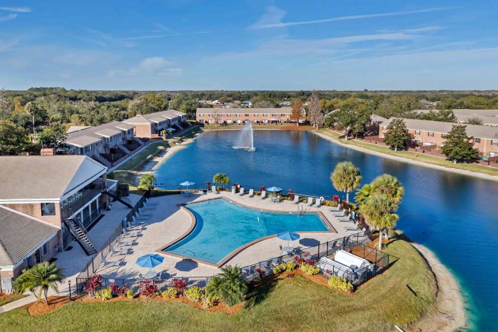 Community swimming poo with lake view at Carlton Arms Of South Lakeland in Lakeland, Florida