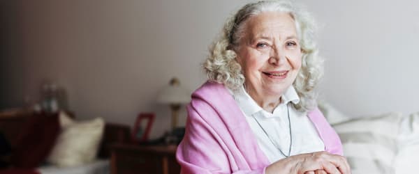 Resident smiling while relaxing in her apartment at Lake Forest at Swift Creek in Midlothian, Virginia