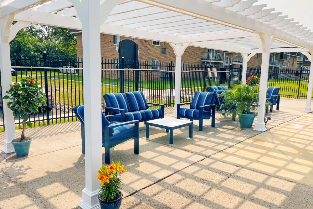 Poolside lounge with seating covered by a pergola