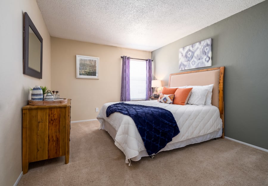 Master bedroom with plush carpeting at The Fairway Apartments in Plano, Texas