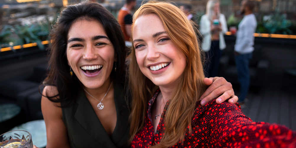 Smiling friends enjoying a roofdeck near Club Prado in West Miami, Florida