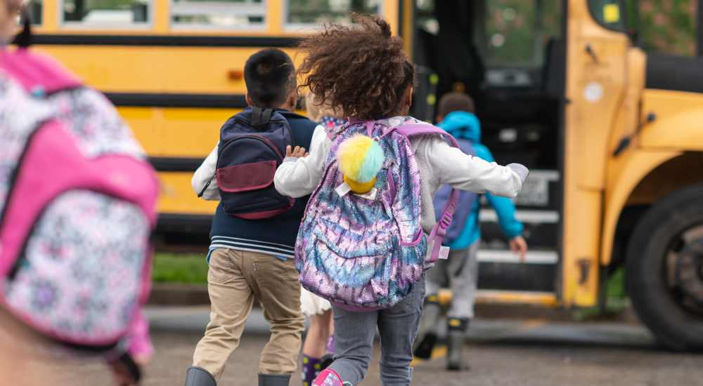 Children running towards school bus at Ashford Lakes in Houston, Texas
