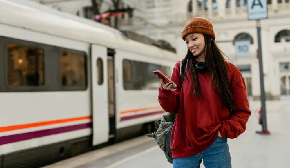 Resident waiting at station with phone near Park City Place in Bridgeport, Connecticut