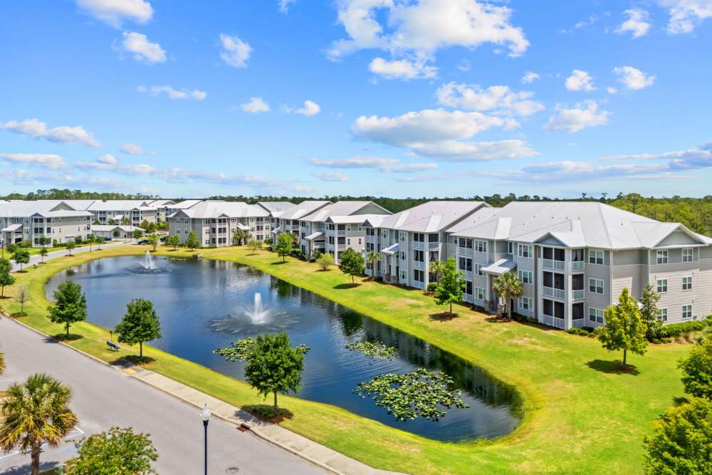 Pond and building exteriors at Pier Park Crossings Apartments.