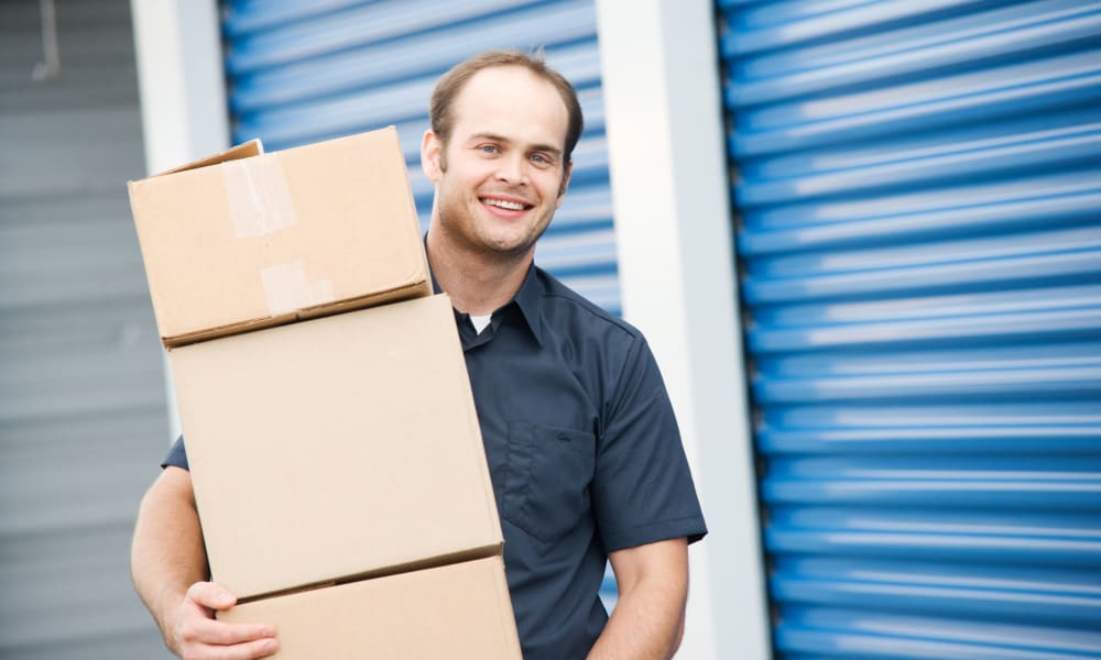 A man carrying boxes at Redmond Mini Storage in Redmond, Washington.