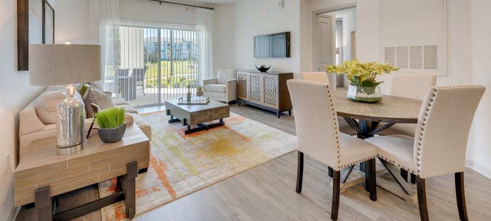 An open floor plan featuring a model living room and dining area at Champions Vue Apartments in Davenport, Florida