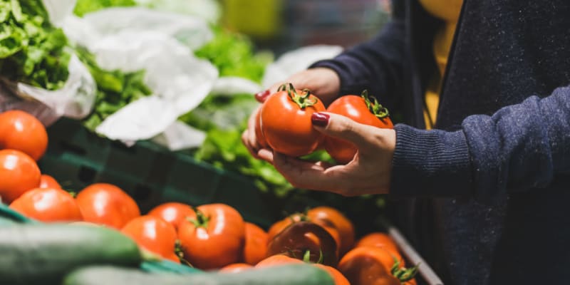 A resident selecting tomatoes at a store near O'Neill Heights in Oceanside, California