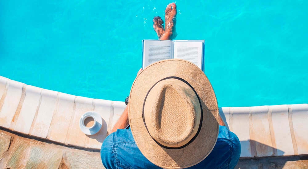 Resident relaxing on the edge of a swimming pool at Retreat at Redstone in Crestview, Florida
