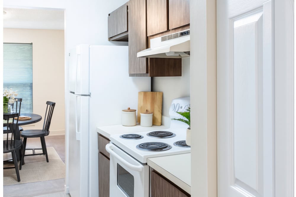 Fully equipped kitchen and view of cozy dining space at Fulton Hill Apartments in Tallahassee, Florida