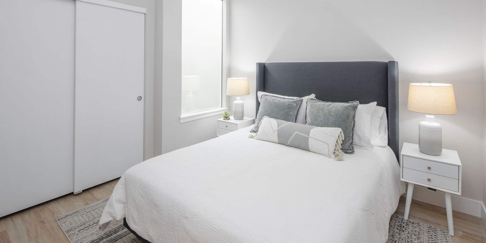 A bed and side tables in a model apartment bedroom at Copper Range in Colorado Springs, Colorado