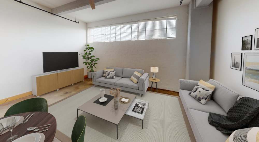 Spacious living room with a couch and TV setup at Star Lofts in Petersburg, Virginia