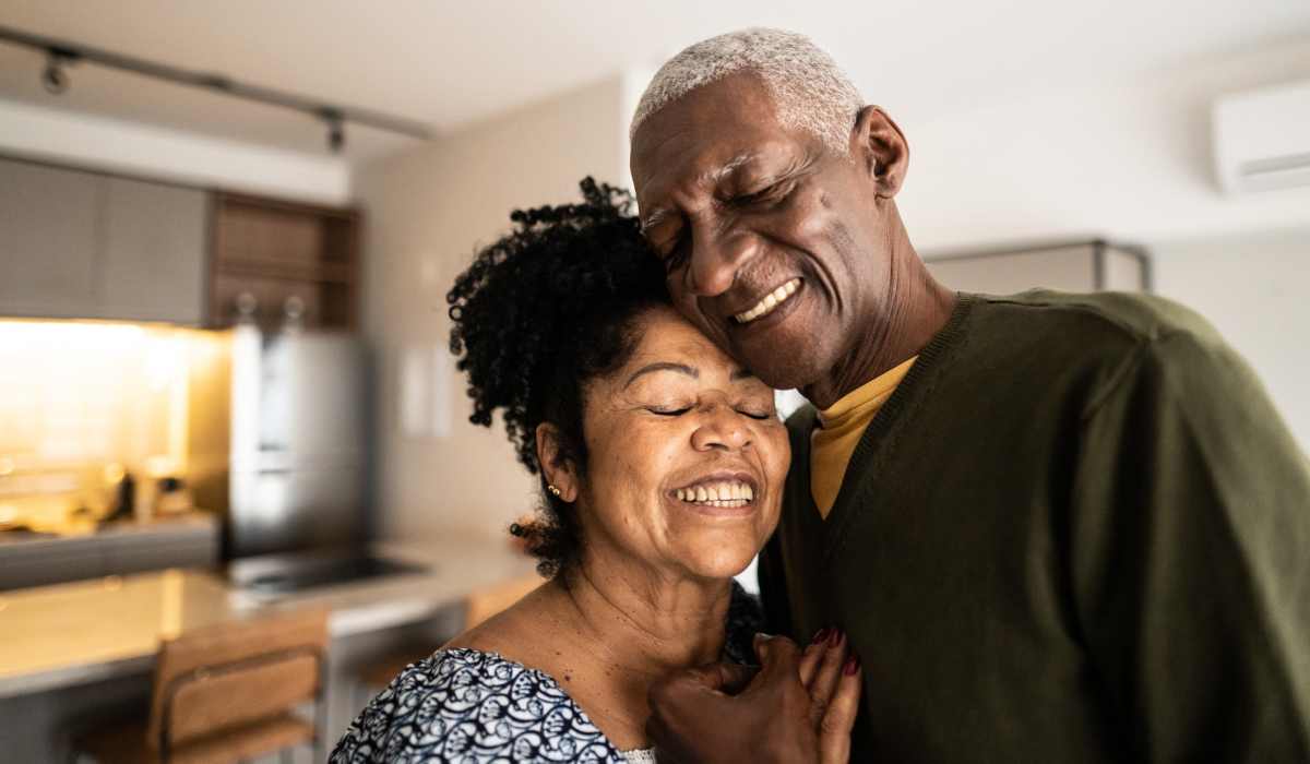 A happy couple hugs in their apartment at Attain at Towne Centre, Fredericksburg, Virginia
