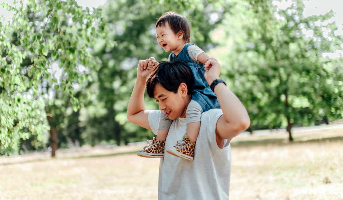 Resident father carrying his daughter on his shoulders at a park near Castle Point in South Bend, Indiana