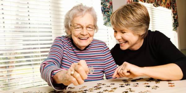 Resident doing a puzzle with her daughter at Wellington Place at Fort Atkinson in Fort Atkinson, Wisconsin
