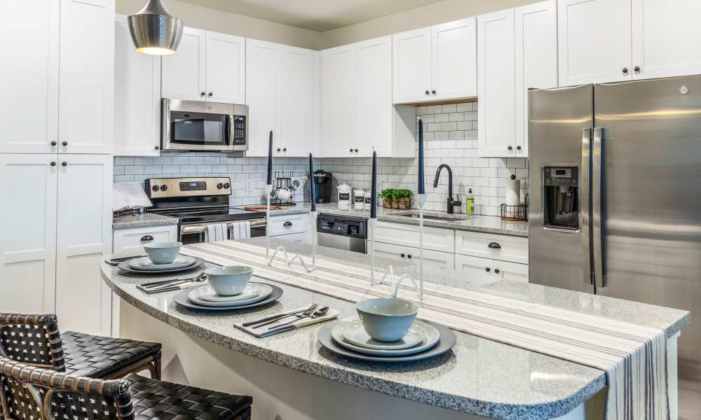 Modern kitchen with white cabinets and island seating at Brisa at St. Augustine in St. Augustine, Florida