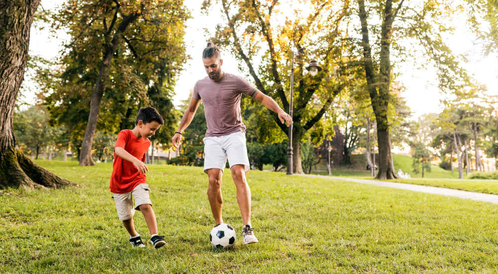 Father and son playing football in a park near Coral Wood Court in Reseda, California