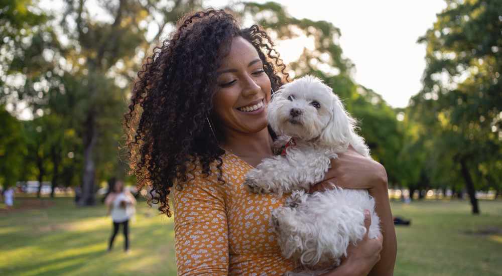 A woman cuddling her pet in a park near Stonebridge at the Ranch Apartments in Little Rock, Arkansas